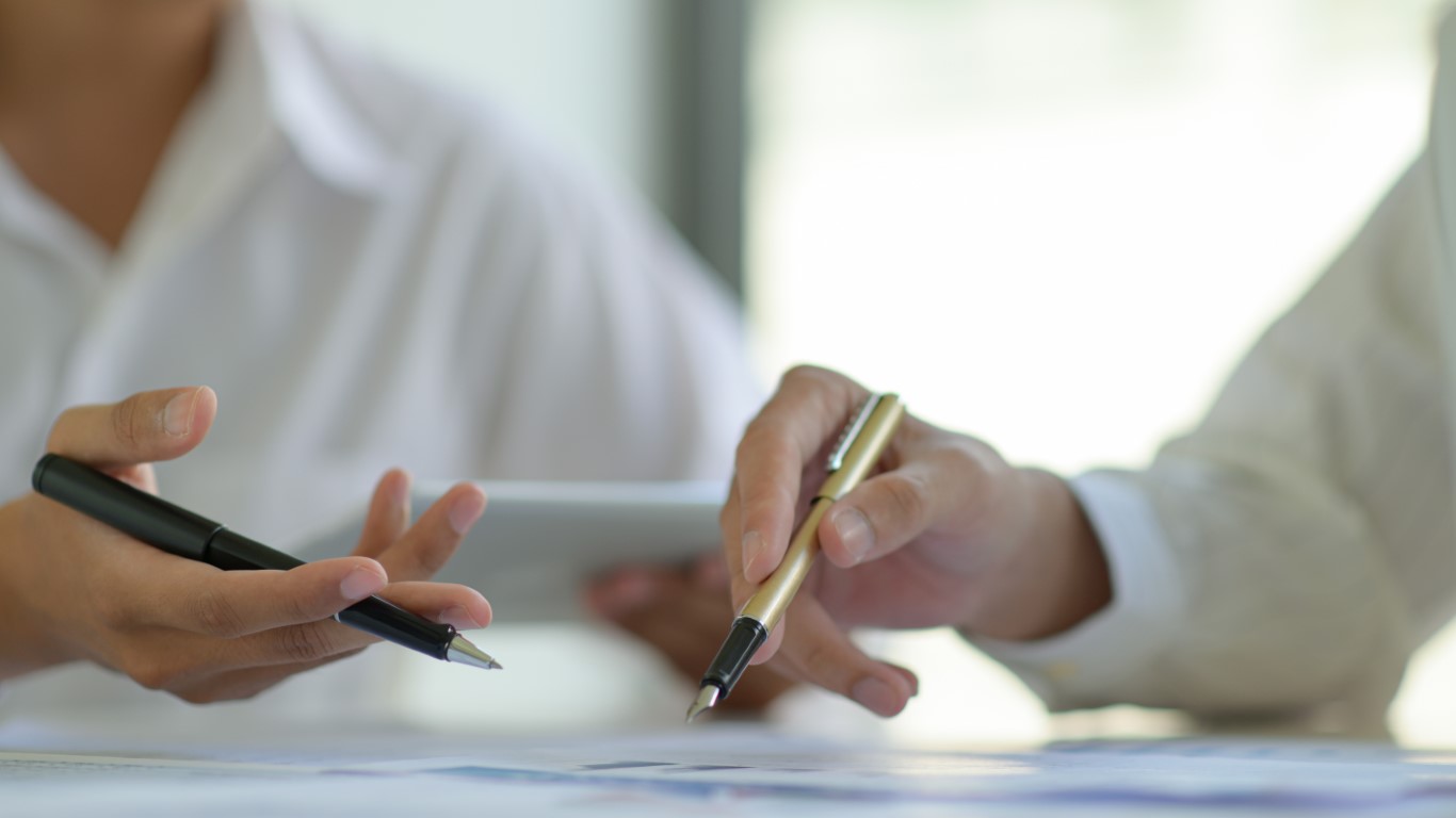 Business office staff are analyzing data graphs to summarize annual results.