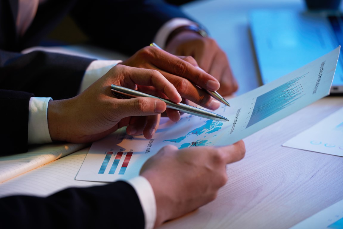 Close-up image of business executive showing financial report to his coworker